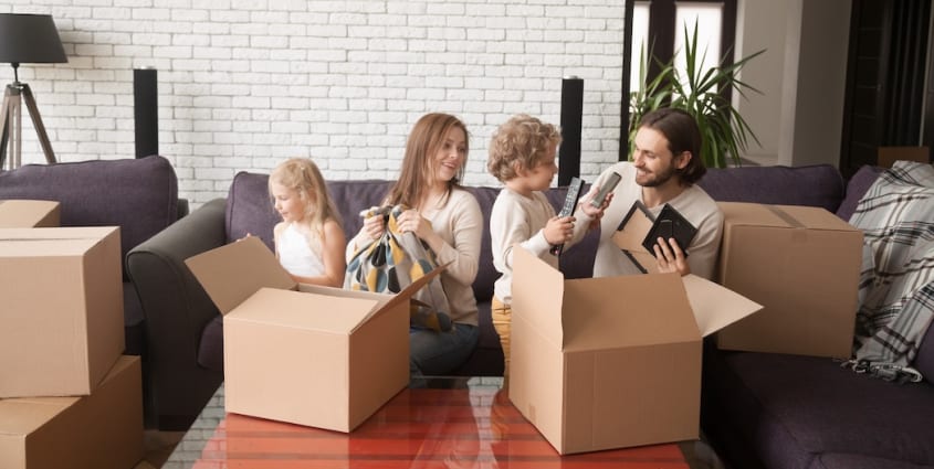 Family surrounded by boxes moving into a new home