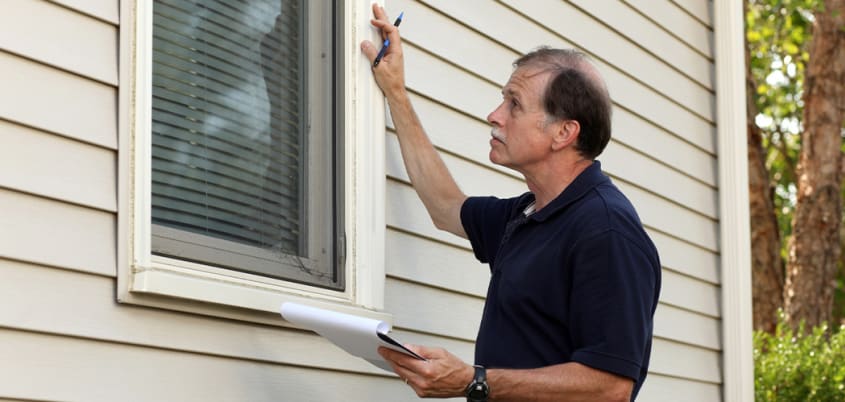 Inspecteur inspectant la fenêtre d'une maison