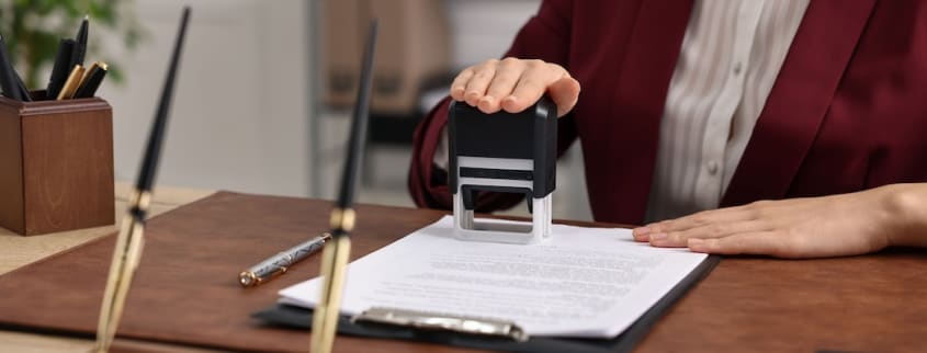 A notary stamps a legal document related to a home sale