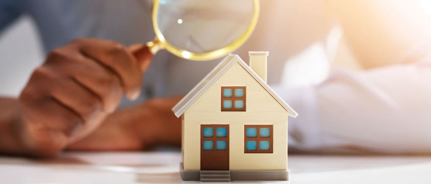 Magnifying glass over a miniature house