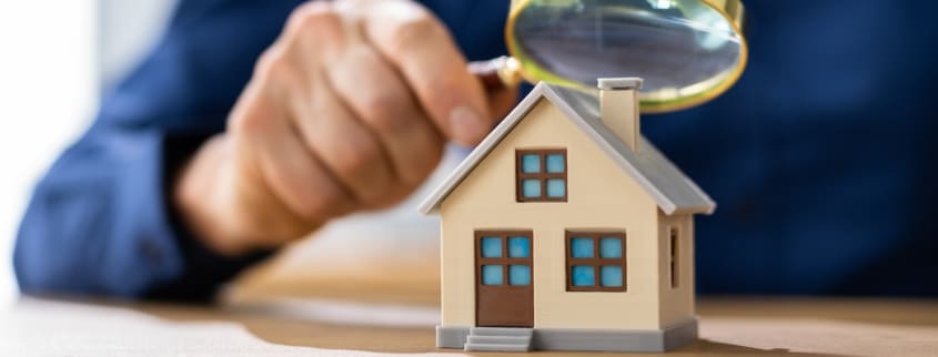 A man is looking at a tiny house with an hourglass