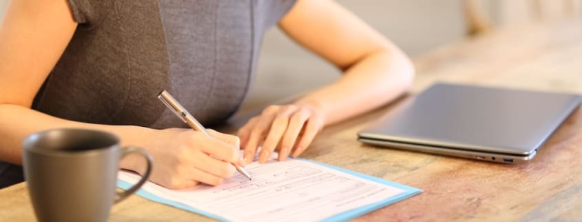 Une femme remplit un formulaire d’offre d’achat pour une propriété