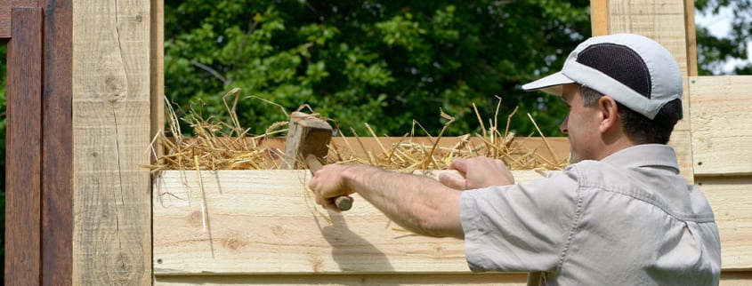 Man using straw to insulate a wall